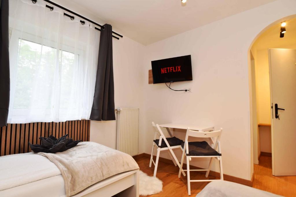 Zimmer mit Schreibtisch, Sesseln und Smart-TV