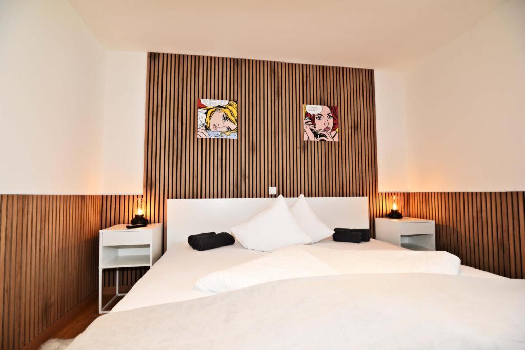Doppelbett mit Bildern an der Holzwand